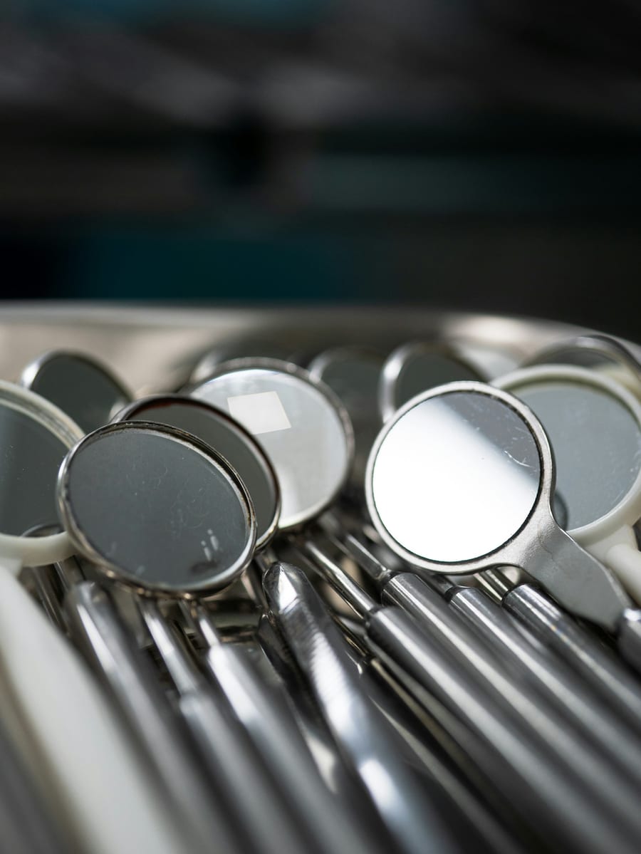 Sterilised dental mirrors and instruments arranged in a steel tray